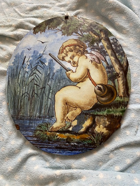 
															Médaillon ovale céramique polychrome figurant un putto dans les roseaux
														