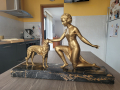 
													Socle en marbre noir avec statue femme agenouillée caressant un chien
												