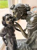 
													Sculpture bronze d'une femme embrassant son enfant
												